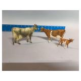 Two DeLaval tin advertising cows, one calf