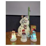 Three Avon light up snowmen and a stand up Santa