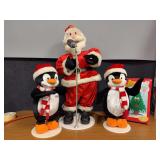 Animated rockin’ Santa, two penguins and a tree Santa