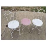 Three soda fountain chairs and one mismatched iron chair with no seat