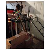 Various long handled yard tools and storage rack
