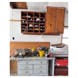 Workbench with contents, contents on shelves Includes oil, trophy toppers, mugs, hand tools, bench vise, grinder, etc Bench measures approx 10x50x32