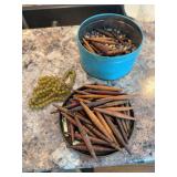 Tin full of “pine cone” style beads approx 3” long made of wood/paper? and “glass” beads that look like corn kernels