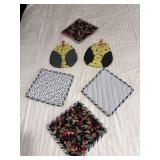 Four hot pads and a pair of oven mitts
