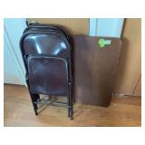 Square folding table and four brown metal folding chairs