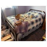 Full-size bed with vintage metal frame and small side table with milk glass hobnail lamp