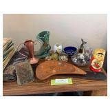 Collectible items includes cowbell, wooden tray with pennies, lady shoe vase, some rocks, paper weights, Russian nesting doll