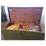 Vintage cedar chest painted green, with assorted blankets and afghans