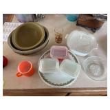 Kitchen collectibles include melamine mixing bowls, Correlle plates, glass juicer, Davey Crockett juice glass, and three Pyrex refrigerator dishes