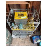 Two milk crates, glass insulators, pop bottle, and biscuit tin