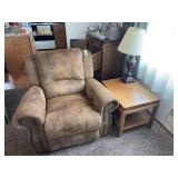 Oversized brown recliner with nail head design, the foot rest tends to pop out at will, also includes wooden end table, and table lamp