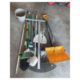 Assortment of handled items, including shovels, rake, drywall square and some cleaning supplies