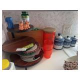 Kitchen counter decor, including display shelf, plastic pitcher and glasses, ceramic canister set, trays on top of stove