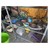 Two lower shelves of yard and garden decor, including painted rocks
