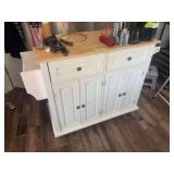 Rolling kitchen island with butcher block style countertop, and small assortment of kitchen gadgets inside