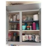 Kitchen cupboard full of coffee mugs, plastic glasses, Ramekins, measuring cups