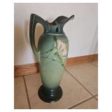 Roseville Freesia pottery pitcher in green. It features the iconic Freesia blossom design, a blended green glaze, and a distinctive tapered body with a single handle.  Pattern: Freesia, 15'h