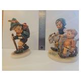 Two Goebel Hummels - 'Homeward Bound' figurine (model number #334), featuring a girl and boy walking with a goat and Flower Vendor,' identifiable as model #381