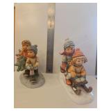 Berta Hummel Goebel figurine titled 'Tree Trimming Time' from 1996, (BH12) and M.I. Hummel porcelain figurine titled 'Winter Days' (HUM 2072), depicting two children on a sled