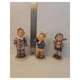 Goebel Hummel figurine titled 'It's Cold', Model Number: 421.  Hummel Goebel figurine titled 'Boy with Toothache', Model Number #217.  Goebel Hummel figurine named 'Carnival' (Model #328), depicting a