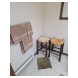 Two stools towels and bathroom rugs