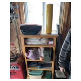Solid wood bookshelf with two empty ammo cases, an HP printer, and a roll of shrink wrap