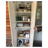 Double door white storage cupboard with assortment of kitchen items, small appliances, stainless roaster, toaster, food process, nesting bowls