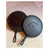 Cast-iron griddle marked 8 and cast-iron skillet with an S on the bottom