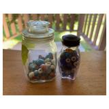 Two small glass containers full of antique trade beads