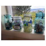Three jars full of sea glass and additional blue jar with thread spools