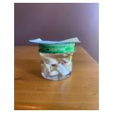 Small jar full of opalized white iridescent stones, suspended in oil