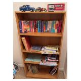 Small bookcase and contents includes fiction books, Little Golden books, die cast cars, etc