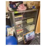 Metal bookshelf with sliding glass doors and contents