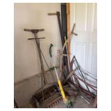Long handled yard tools and 2 old mowers