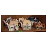 Shelf of house shaped tea pots