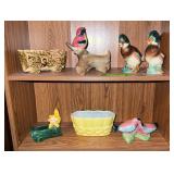 Two shelves of planters and duck figurines Bill of one duck is broken