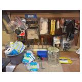 Wall rack with lots of gun cleaning items, some hand tools, pegboard hooks, scope rings