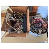 Tin and box full of costume jewelry