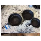 Three graduating cast-iron skillets