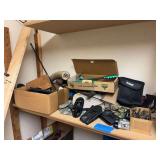 Shelf of miscellaneous hunting type items, hunting license pins, reloading press, holster, hand warmers, horns