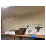 Liberator pistol plaque, information, and multiple copies of the book.