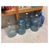 Two glass carboys, and four plastic water jugs