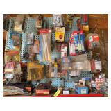 Blue pegboard full of products from tail lights to spark plugs to trailer lighting kits chain splice links, sprinkler heads, drill bit sharpener, many dollars worth of stuff