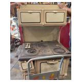Colonial Universal Number 85 36" tan enamel wood cook stove with warming oven and enamel legs pretty much complete one bracket is broken on the back oven top BRING HELP TO LOAD!!