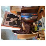Box full of pet supplies, including car seat covers, nail clippers, activity box, grooming supplies