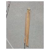 vintage multi-piece split bamboo fly fishing rod resting in a gray fabric storage sleeve.