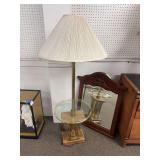 Brass floor lamp with wall hanging wood framed mirror