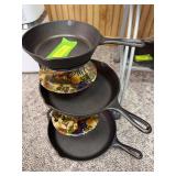 Three Lodge skillets marked 4 5SK, 1 8SK and 2 10SK with stand