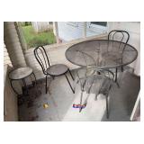 In corner includes 42” round expanded metal table, three chairs and small plant table