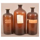 Three Amber Apothecary Bottles, One Marked Poison.